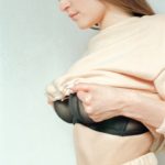 a woman in a white top and black bra