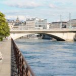 a bridge over a body of water with buildings in the background