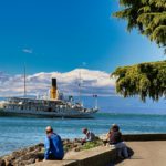 A group of people sitting next to a body of water