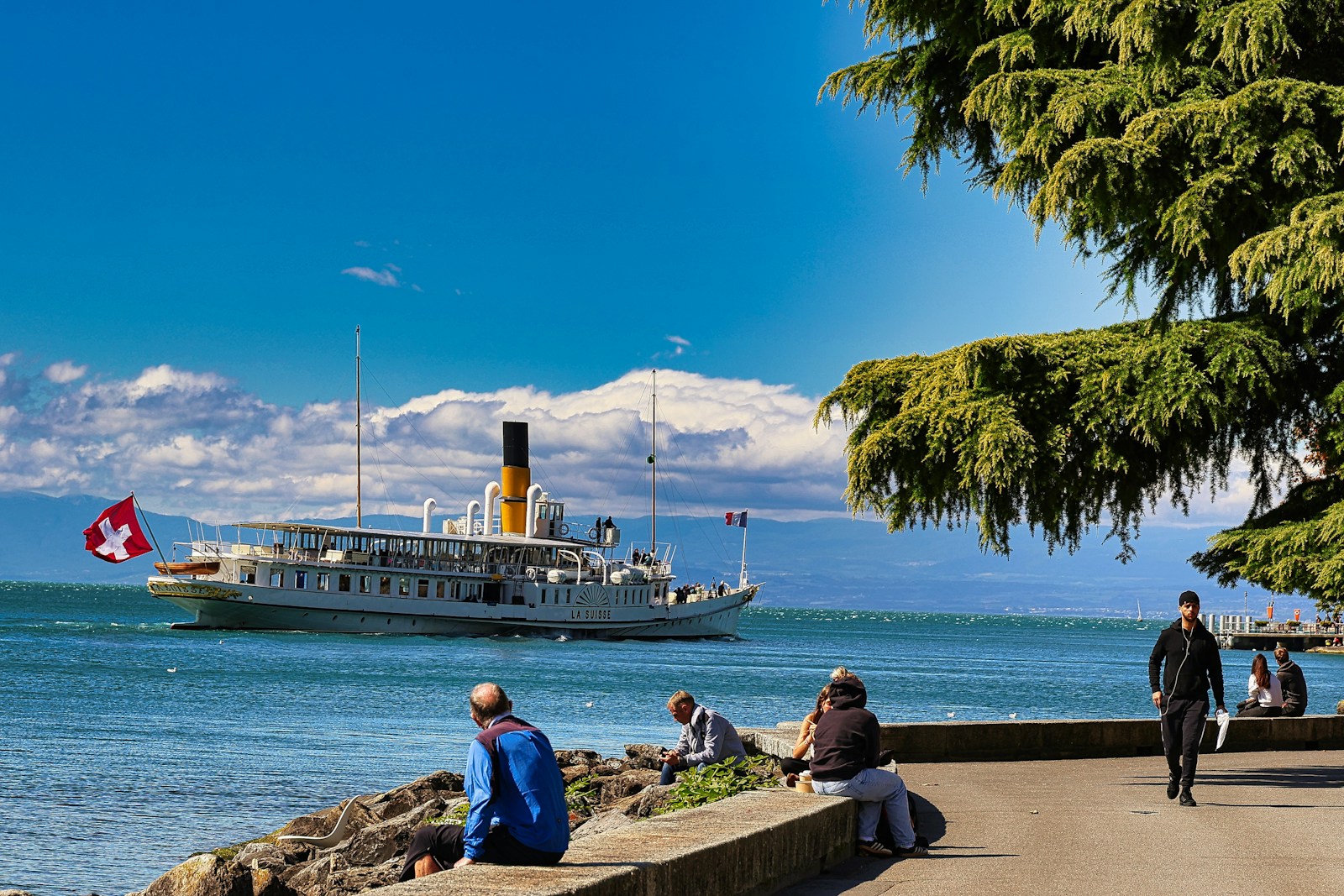 A group of people sitting next to a body of water